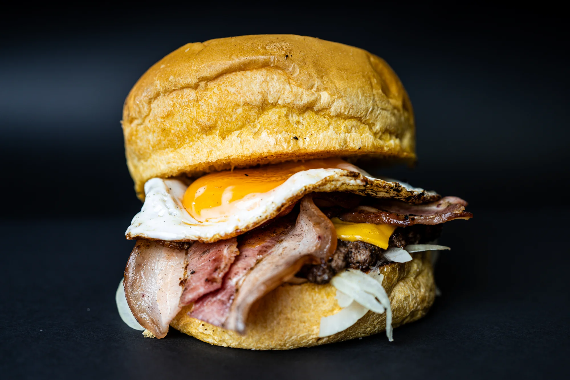 Hamburguesa fotografiada sobre un fondo oscuro